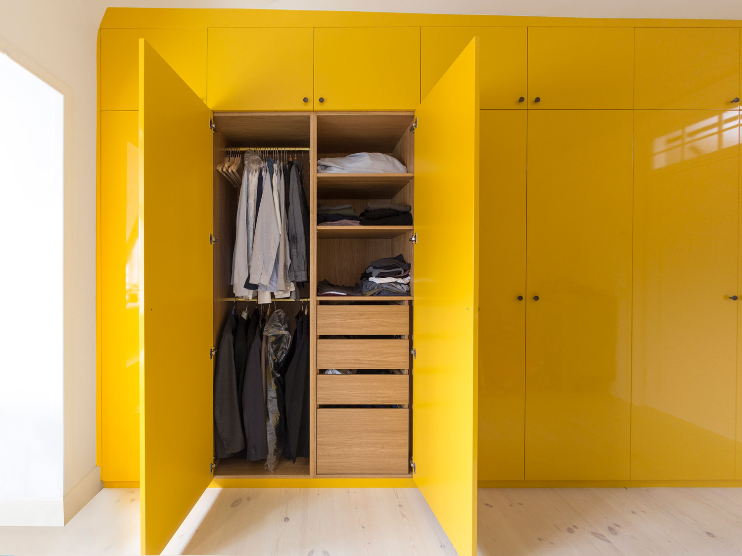 Indretningen er udført i eg med hylder, skuffer og bøjlestænger skabt ud fra familiens ønsker og behov.